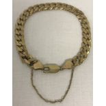 A 9ct gold curb chain bracelet with lobster clasp and safety chain.