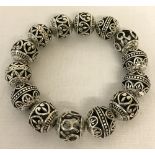 An expanding bracelet with carved white metal beads.