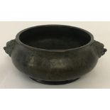 A fire bronze censer with foo dog design handles.