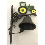 A painted cast iron, wall hanging garden bell with tractor detail.