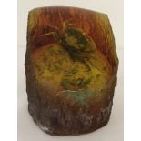 A figurine of a small fossilised crab sitting on a pebble set in resin, possibly amber.