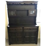 A large dark wood 2 sectional Grangemoor dresser with leaded glass doors.