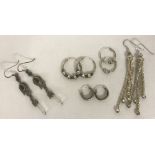 5 pairs of silver and white metal earrings.