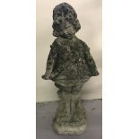 A concrete garden ornament of young girl.