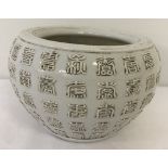 A white glaze Chinese porcelain pot with calligraphy detail.