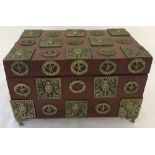 A 2 handled wooden box decorated with oriental brass plaques and raised on ornamental brass feet.