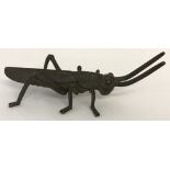 A small Chinese bronze figure of a cricket, signed to underside.