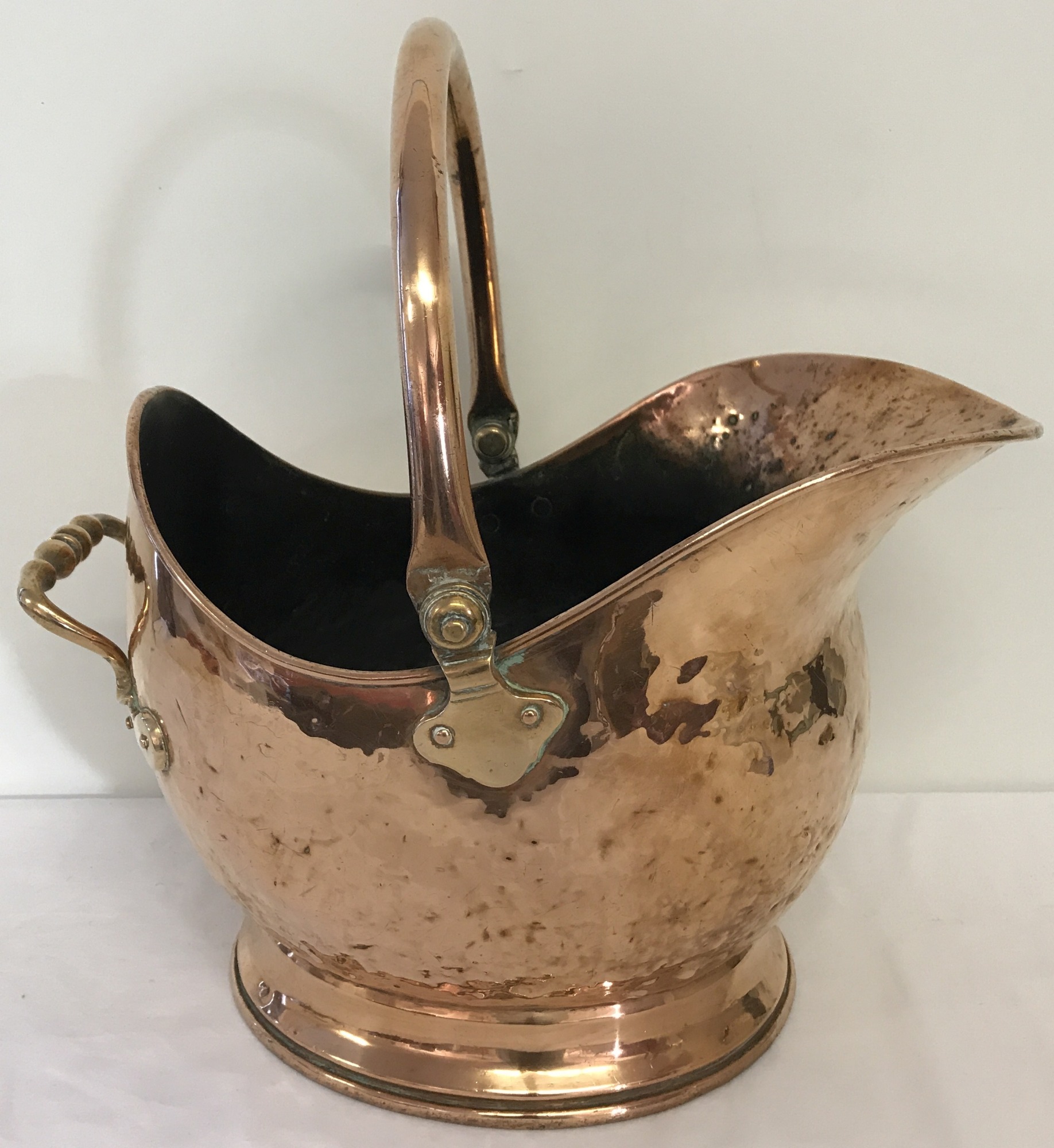 A vintage copper coal scuttle with hinged handle.