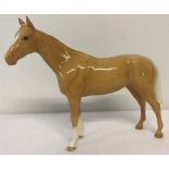 A Beswick Bois Roussell Racehorse figurine in Palomino colourway with circular back stamp.