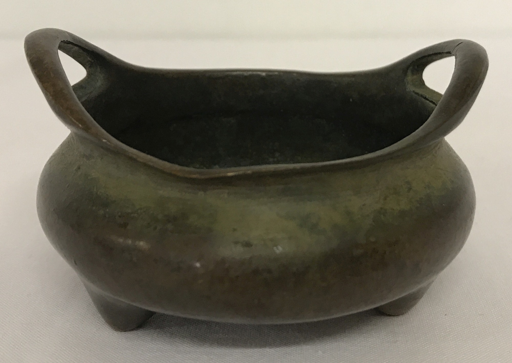 A small Chinese bronze 2 handled censer raised on tripod feet.