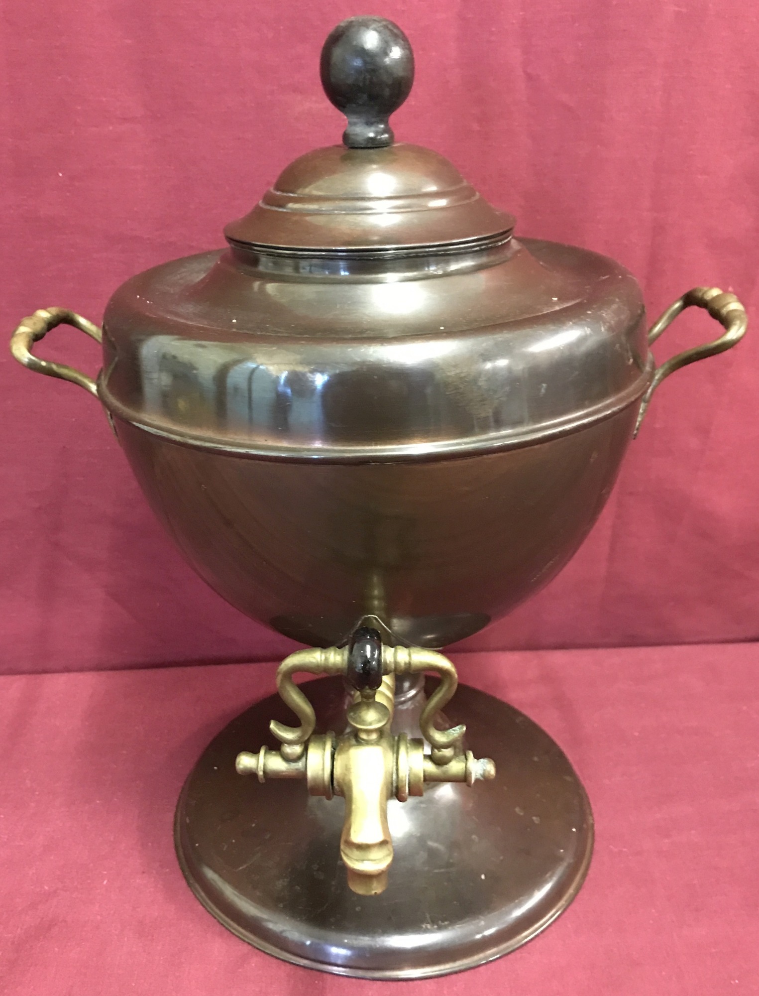 A vintage copper samovar with brass handles and tap and wooden finial.