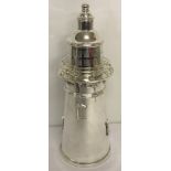 A large silver plated cocktail shaker in the shape of a lighthouse.