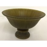 A circular shaped libation cup raised on a central pedestal base.