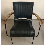 A new wrought iron framed arm chair with wooden arms and petrol blue leather seat and back.