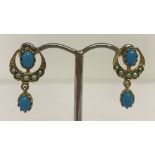 A pair of 9ct gold crescent moon design drop earrings set with turquoise and seed pearls.