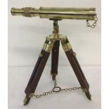 A small brass telescope together with a wooden and brass tripod stand.