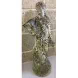 A concrete garden ornament of a classical style lady carrying a basket.