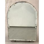 A small arch-shaped, free-standing vintage mirror.