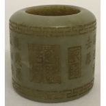 A jade archers ring with carved Greek Key design to top and bottom rim and Chinese characters around