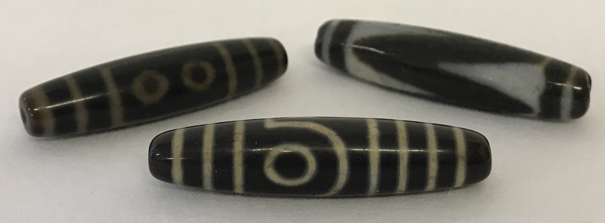 3 Tibetan dzi beads.