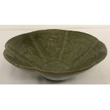 A Chinese celadon glazed bowl with scalloped rim.