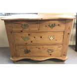 A vintage pine 4 drawer chest with curve fronted detail and brass drop down handles.