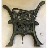 A pair of decorative cast iron bench ends, painted dark green.