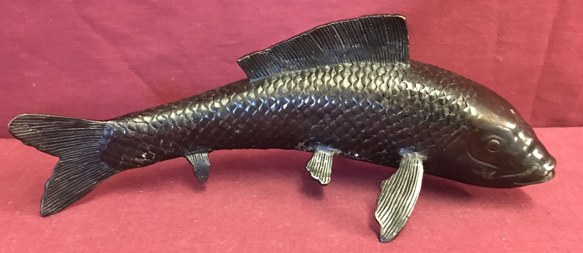 A hollow bronze figure of a fish.