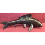 A hollow bronze figure of a fish.
