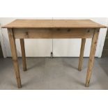 A natural pine kitchen table with square legs.