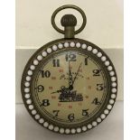 A brass cased pocket watch with beaded detail to surround front and back.
