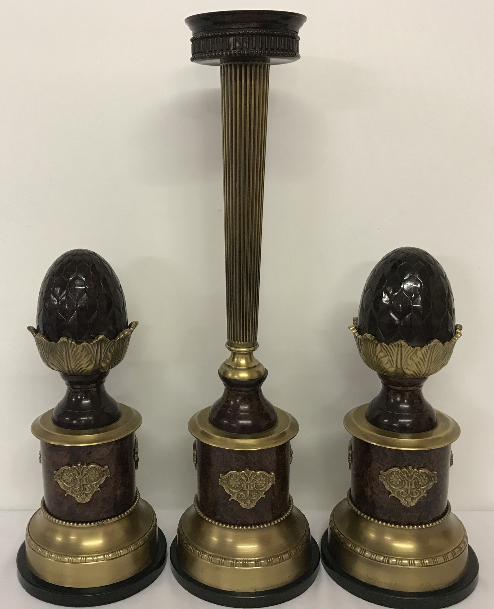 A 3 piece vintage metal candle stand garniture on marble bases, with acorn detail.