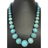 A graduating turquoise bead necklace with silver clasp and adjustable extension chain.