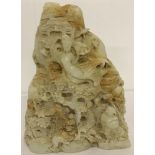A large piece of white jade carved with an Oriental scene depicting houses, figures and trees.