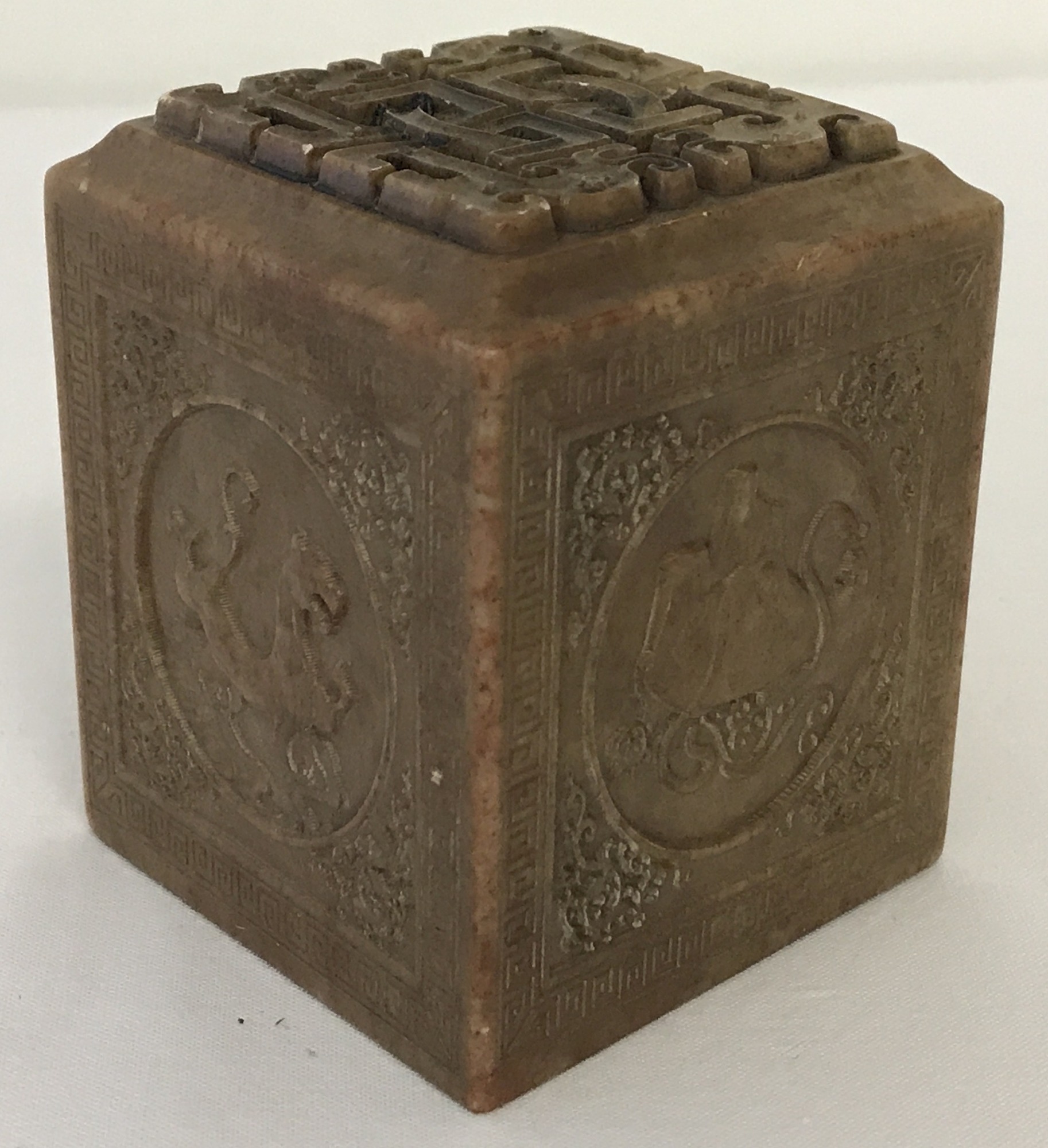 A Chinese carved soapstone seal with mythical creature detail to each side.