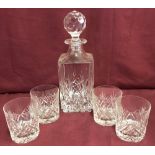 A crystal whiskey decanter and 4 matching tumblers.