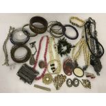 A collection of vintage and modern costume jewellery bracelets, necklaces and brooches.