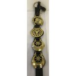 A vintage leather strap containing 4 horse brasses.