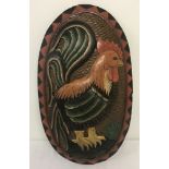 An oval carved and painted wooden wall hanging plaque of a cockerel.