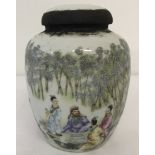 A small Chinese porcelain tea jar with figural detail to sides. Sealed and with contents.