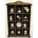 A small wooden display case containing 12 miniature clocks.