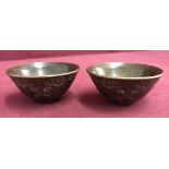 A pair of small oriental bronze bowls with elephant detail to outer bowl.