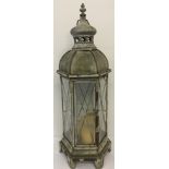 A metal and glass Moroccan style garden lantern with carry handle.