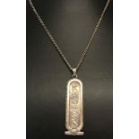 An Egyptian silver pendant with hieroglyph decoration to both sides. On a 20 inch curb chain.