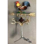 A modern painted cast metal weather vane with cockerel detail.