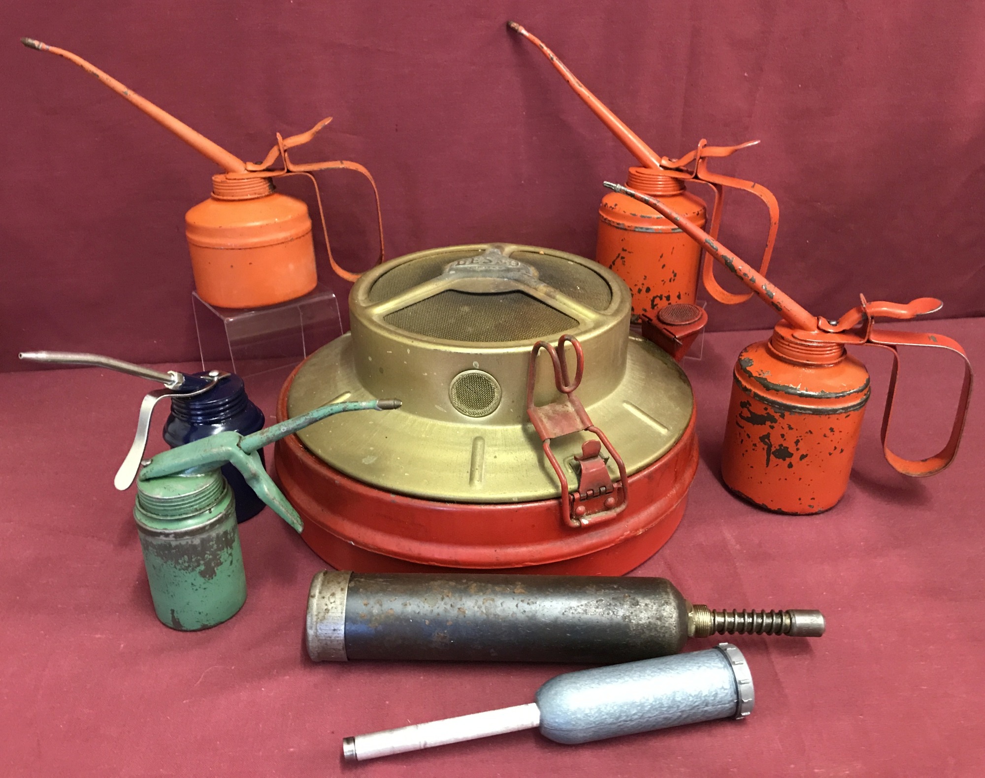 5 vintage oil cans together with 2 grease guns and an under car paraffin heater.