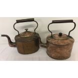 2 vintage oval shaped copper kettles with metal handles.