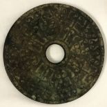 An unusual circular medallion in the style of a Bi disc, with oriental style design.