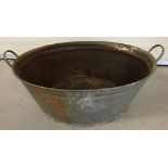 A vintage oval tin bath by Regina, with carry handles.