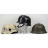 4.1.) Uniformen / Kopfbedeckungen3. Reich: Lot von 3 Stahlhelmen.1.) SS Wintertarnung, 2.) NS-